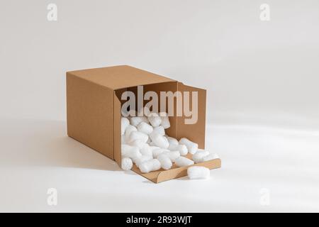 Cardboard box isolated on the white background filled with packing peanuts Stock Photo