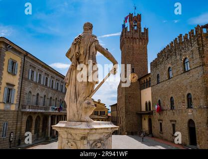 Arezzo, impressive view of Piazza Duomo and its historical buildings with Ferdinando de Medici statue in foreground, Tuscany, Italy Stock Photo