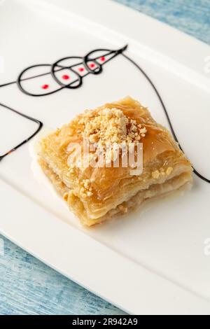 Turkish baklava with hazelnuts on a white porcelain plate Stock Photo