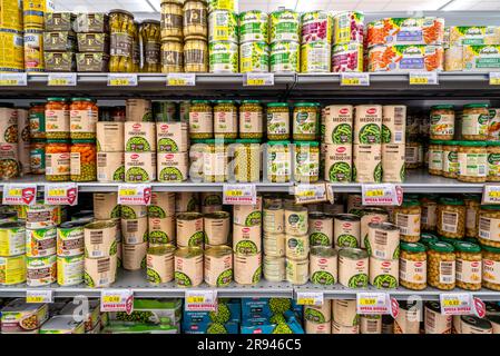 Italy - June 22, 2023: Green beans, peas and chickpeas and other canned vegetables in glass jars on shelves for sale in Italian supermarket Stock Photo