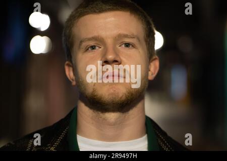 A close-up of a young, British man with green eyes looking into the distance Stock Photo