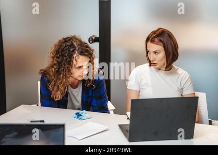 Confident female employee sharing business ideas with her male colleague Stock Photo