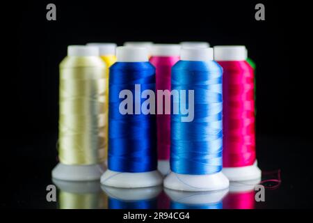 set of different color sewing threads, isolated on black background. Stock Photo