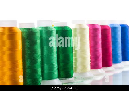 set of different color sewing threads, isolated on white background. Stock Photo