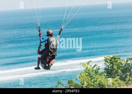 Paraglider flies in front of the ocean Stock Photo