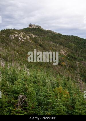 From the pine-covered base, the top station of Whiteface Mountain is seen in the distance. Stock Photo