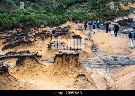 Taipei, Taiwan -- March 14, 2023. A photo of tourists walking amid the famous rock formations in Yehliu Geopark. Stock Photo