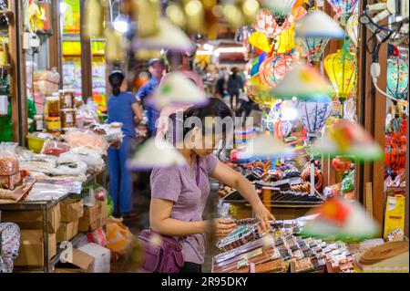 A female vendor tends to her crafts stall in Hoi An Market in old town Hoi An, Vietnam. Stock Photo