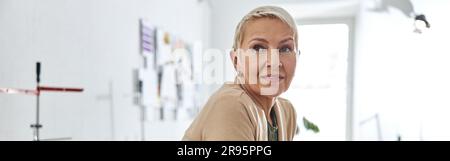 Portrait of cheerful designer in stylish jacket leaning onto whi Stock Photo