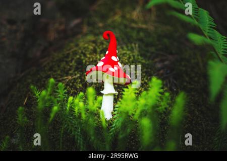 Fabulous plasticine fly agaric in the forest. Green blurred natural background. Stock Photo