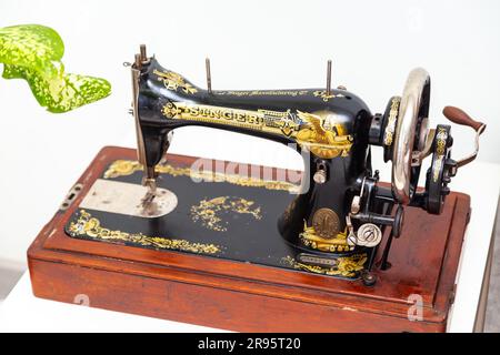 Vintage sewing machine  Singer on a light background. St. Petersburg, Russia - June 24, 2023. Stock Photo