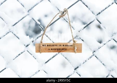The sentence We believe in making a difference was written. Wooden concept studio shoot. Stock Photo