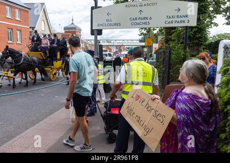 Ascot, UK. 24th June, 2023. Racegoers on a horse-drawn carriage pass an animal rights campaigner as they arrive for the fifth day of Royal Ascot. 28 horses died in jumps and flat races at Ascot between 2012-2022. Credit: Mark Kerrison/Alamy Live News Stock Photo