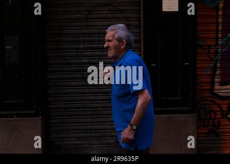 Pamplona, Spain - July, 31: Old man wearing a blue shirt walking down the street of Pamplona Stock Photo