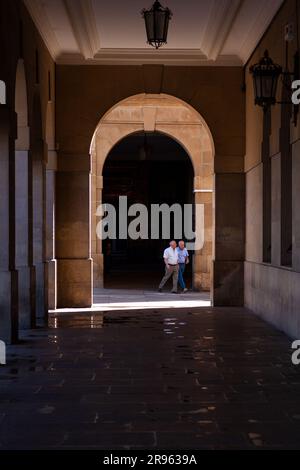 Pamplona, Spain - July, 31: An elderly couple of men walking in the Arched colonnade by the historic Plaza del Castillo square in old Town Stock Photo