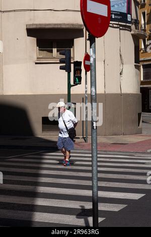 Pamplona, Spain - July, 31: Old man cross the street at the zebra crossing Stock Photo