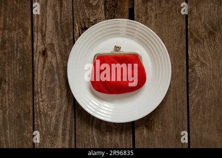 red wallet lies on a white plate on the table close-up Stock Photo