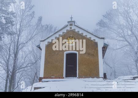 Bardo, Poland - January 2023: Mountain chapel of Our Lady of Weeping in Bardo mountains full of snow and fog at winter Stock Photo