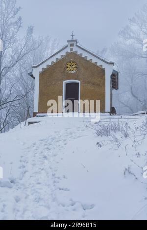 Bardo, Poland - January 2023: Mountain chapel of Our Lady of Weeping in Bardo mountains full of snow and fog at winter Stock Photo