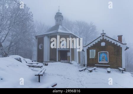 Bardo, Poland - January 2023: Mountain chapel of Our Lady of Weeping in Bardo mountains full of snow and fog at winter Stock Photo