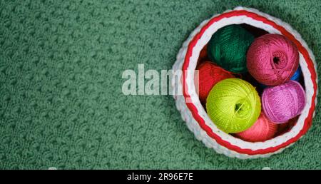 Yarn for crocheting. Top view, web banner with copy space. Concept hobby of handmade needlework from home. Several woolen multicolored balls of thread Stock Photo
