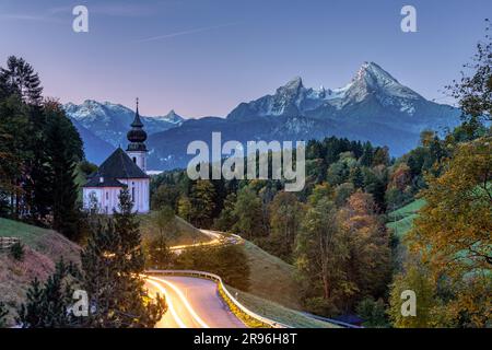 The Watzmann and the small church of Maria Gern at dusk with traces of light from a car headlight Stock Photo