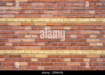Background of a red brick wall with yellow stripes Stock Photo