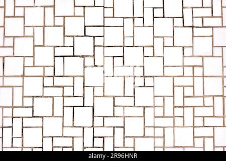 Background made of a wall of square and rectangular white mosaic tiles Stock Photo