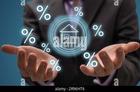 Smart home technology concept. Glowing digital security home lock symbol hologram appearing on smartphone in businessperson's hands. Smarthome safety Stock Photo