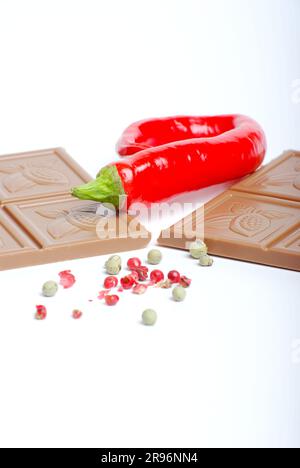 Bar of light chocolate with peperonis, peppercorns (Capsicum annuum), piri-piri, peppers, paprika, milk chocolate Stock Photo