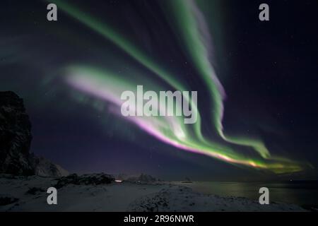 Northern Lights (Aurora borealis) in green and rare pink over the bird cliff of Bleik, Vesteralen, Norway Stock Photo