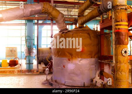 Large iron heat exchanger, tank, reactor, distillation column in thermal insulation of fiberglass and mineral wool of galvanized steel in the industri Stock Photo