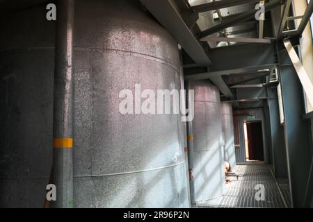 Large iron heat exchanger, tank, reactor, distillation column in thermal insulation of fiberglass and mineral wool of galvanized steel in the industri Stock Photo