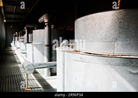 Large iron heat exchanger, tank, reactor, distillation column in thermal insulation of fiberglass and mineral wool of galvanized steel in the industri Stock Photo