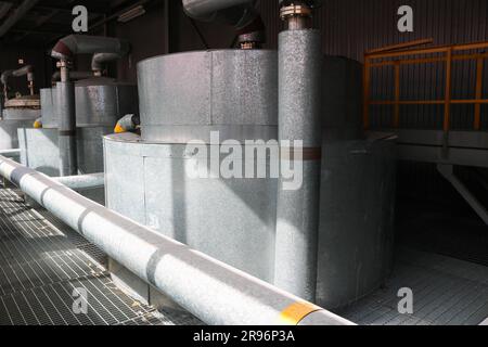 Large iron heat exchanger, tank, reactor, distillation column in thermal insulation of fiberglass and mineral wool of galvanized steel in the industri Stock Photo