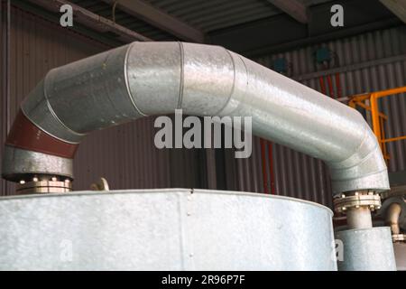 Large iron heat exchanger, tank, reactor, distillation column in thermal insulation of fiberglass and mineral wool of galvanized steel in the industri Stock Photo