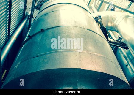 Large iron heat exchanger, tank, reactor, distillation column in thermal insulation of fiberglass and mineral wool of galvanized steel in the industri Stock Photo