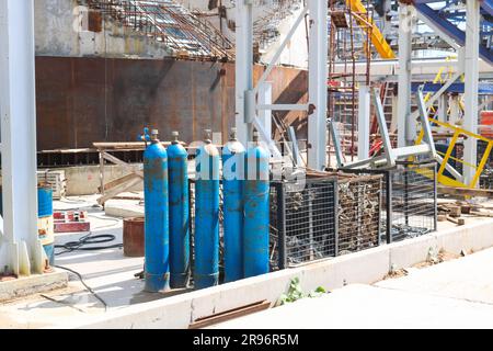 Blue iron metal cylinders with liquefied gas oxygen oxygen air helium argon for welding at the refinery petrochemical plant. Stock Photo