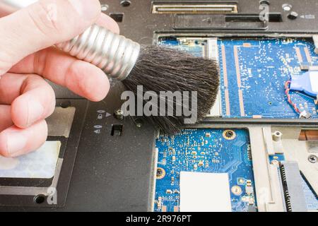 Cleaning the notebook system with a brush during maintenance. Stock Photo