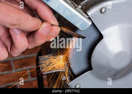 Sharpening knife on old grindstone wheel Stock Photo - Alamy