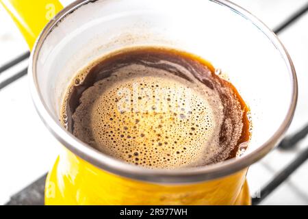 kitchen interior - coffee making in yellow turkey turk on gas stove coffee with foam Stock Photo
