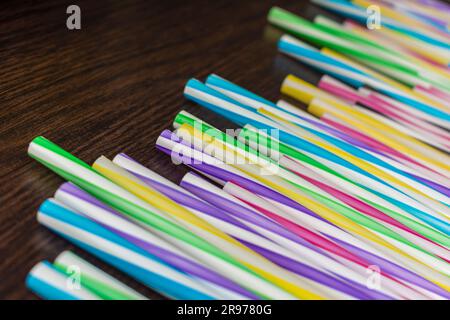 Colorful paper straws on a wooden background. Accessories for events and parties. multicolored background Stock Photo