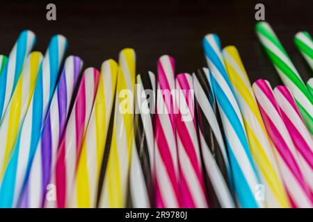 Colorful paper straws on a wooden background. Accessories for events and parties. multicolored background Stock Photo