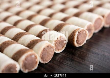 Striped waffle rolls filled with chocolate closeup background Stock Photo