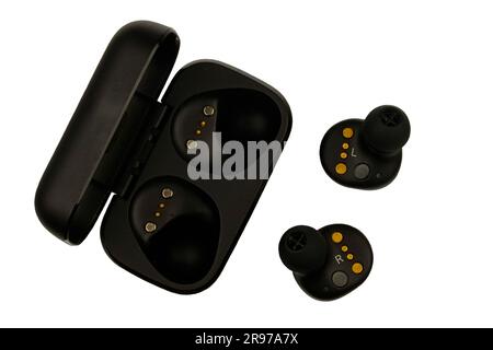 Wireless stereo earbuds. Black wireless earphones and charging case. Earbuds or headphones and charging case with bult-in rechargeable battery for the Stock Photo