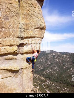 Adult male rock climber ascends a granite face in the Santa Catalina Mountains, Arizona Stock Photo