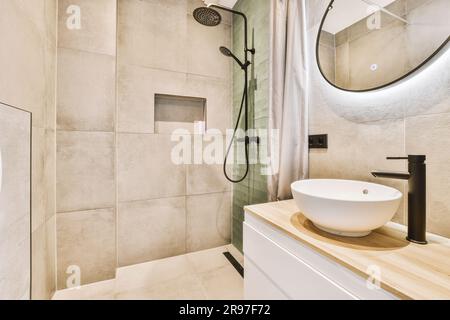 a bathroom with a sink, mirror and shower head mounted on the wall next to the bathtub that's attached to the Stock Photo