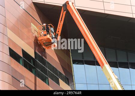 Articulating Boom Lift working at the new BMO (Bank Of Montreal) Centre Expansion in Calgary Alberta Canada Stock Photo