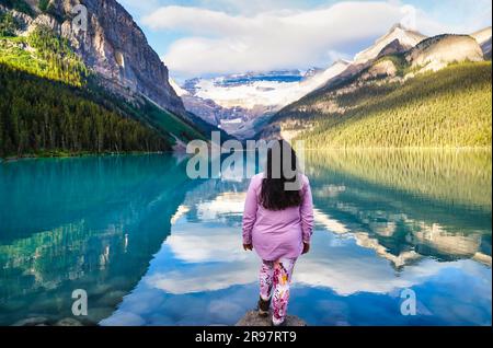 Banff, Canada, August 28th 2022 - A Tourist takes in stunning early morning calm of Lake Louise near Banff in the Canada Rockies Stock Photo