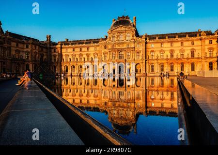 FRANCE.PARIS (75) 1ST DISTRICT. THE LOUVRE MUSEUM REFLECTED IN A BASIN OF THE COUR NAPOLEON AT SUNSET Stock Photo